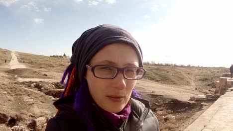 girl-looks-into-the-camera-close-up,-a-wasteland-on-the-site-of-a-former-ancient-fortress