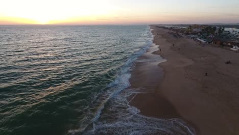 Fliegen-über-dem-Faro-Strand-(Praia-de-Faro)-bei-Sonnenuntergang,-Algarve,-Portugal