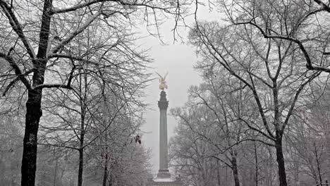 The-Angel-of-Peace-on-the-top-of-Friedensengel-monument-in-Munich,-Germany-during-the-snow-srorm