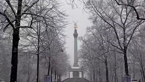 The-Angel-of-Peace-on-the-top-of-Friedensengel-monument-in-Munich,-Germany-during-the-snow-srorm