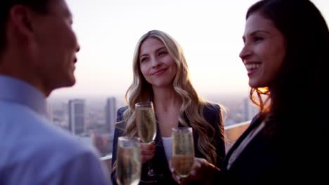 Multi-ethnic-business-team-celebrating-success-on-rooftop