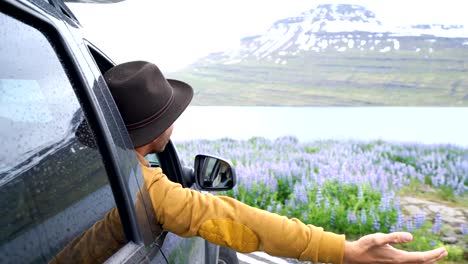 Man-on-road-trip-enjoying-vacations-and-nature-arms-outstretched-freedom-concept