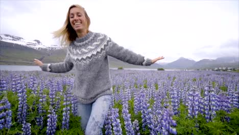 Junge-Frau-läuft-in-lupine-Blumenfeld-in-Island-Leben-ein-glückliches-Leben-und-genießen-Urlaub-im-nördlichen-Land-Slow-Motion-video-Menschen-Reisen-Spaß-Konzept