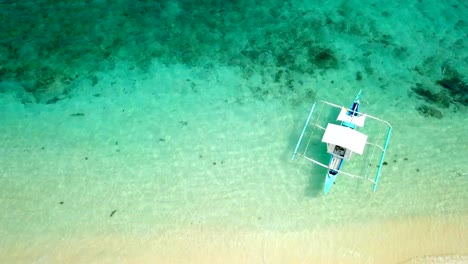 Drone-shot-aerial-view-of-young-woman-lying-down-like-star-shape-on-idyllic-tropical-beach-,-shot-in-the-Philippines