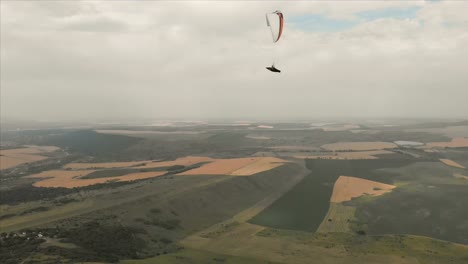 Athlet-Gleitschirm-fliegt-auf-seinem-Gleitschirm-neben-die-Schwalben.-Follow-up-Aufnahmen-aus-der-Drohne