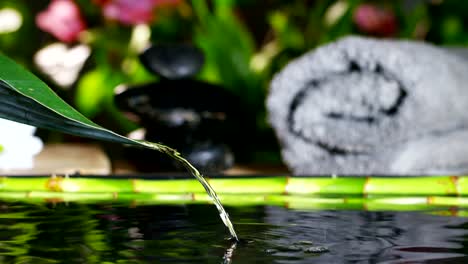 Dispara-a-agua-hermosa-y-la-composición-de-spa-y-wellness-de-velas-en-extremo-lento-motion.concept-de-relax-y-meditation.water