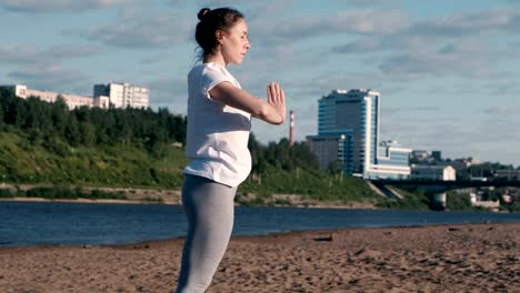 Frau,-dehnen,-Yoga-am-Strand-am-Fluss-in-der-Stadt.-Blick-auf-die-schöne-Stadt.