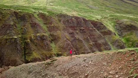 Amazing-drone-point-of-view-of-man-hiking-on-mountain-ridge-over-canyon-in-Iceland