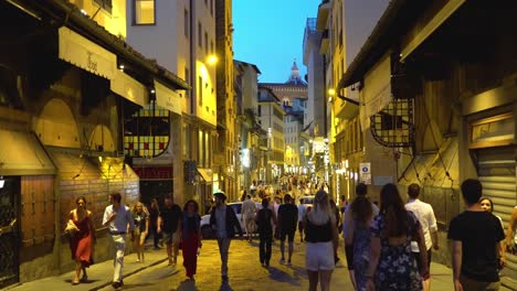 Florence,-Tuscany,-Italy.-People-walk-along-the-illuminated-Via-Via-Por-Santa-Maria-at-night