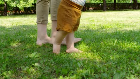 Mujer-y-bebé-caminar-descalzo-sobre-la-hierba