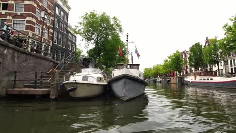 passing-the-boat-with-rainbow-flag-in-Amsterdam,-Holland-Europe