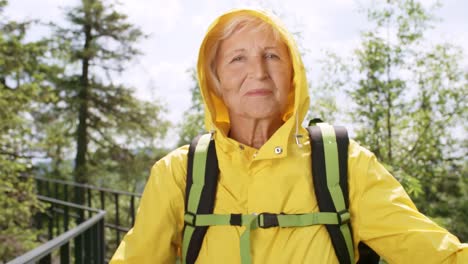 Ältere-Frau-posiert-für-die-Kamera-im-Bergwald