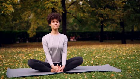 Hübsche-Brünette-streckt-die-Beine-in-der-Schuster-Pose-auf-Yoga-Matte-sitzen-dann-biegen-nach-vorne-entspannt-zurück-und-schloß-die-Augen.-Entspannung-und-Yoga-Konzept.