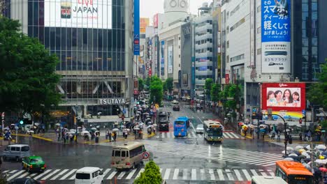 Stadtteil-Shibuya-in-der-regnerischen-Nacht-mit-Publikum-vorbeigehen-Zebrastreifen.-Tokio,-Japan.-4K-Zeitraffer.