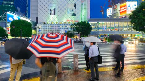 Stadtteil-Shibuya-in-der-regnerischen-Nacht-mit-Publikum-vorbeigehen-Zebrastreifen.-Tokio,-Japan.-4K-Zeitraffer.