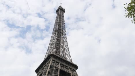 Champs-de-Mars-square-Eiffel-tower-and-symbol-of-France-in-front-of-cloudy-sky