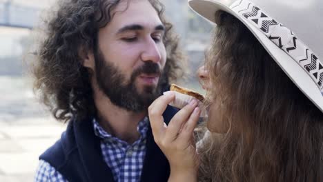 Couple-with-cake-kissing-on-embankment-near-bridge