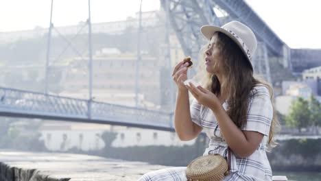 Pretty-woman-enjoying-sweets-on-embankment