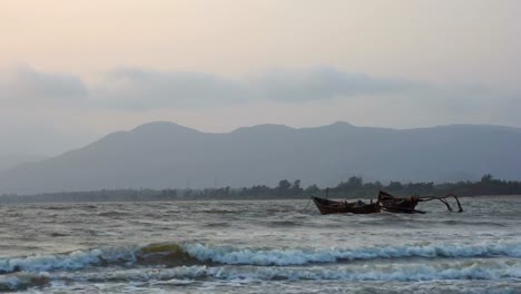 Wooden-boats-tied-floating-on-sea-near-mountain-range.