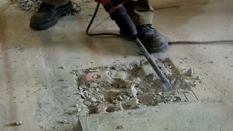 Industrial-workers-drill-concrete-with-Electric-plugger-hammer--at-construction-site.