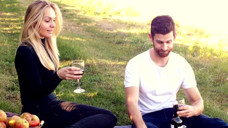 Couple-having-wine-in-orchard