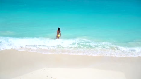 Adorable-niña-en-la-playa-con-un-montón-de-diversión-en-aguas-poco-profundas