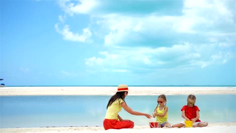 Adorable-little-girls-and-young-mother-on-white-beach