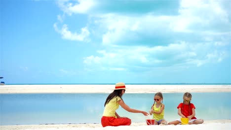 Entzückende-kleine-Mädchen-und-junge-Mutter-am-weißen-Strand