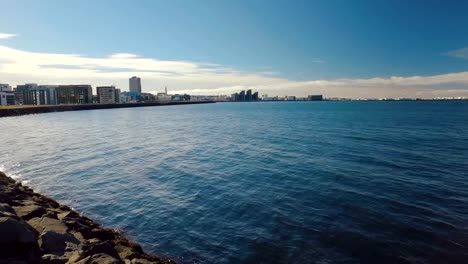 las-aguas-del-océano-Atlántico-y-panorama-de-Reykjavik-en-tiempo-soleado,-vista-desde-puerto-nuevo