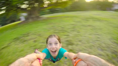 POV-footage-of-father-swinging-his-daughter-outdoors