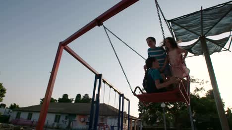 Niños-que-hace-pivotar-juntos-en-un-parque-infantil-público