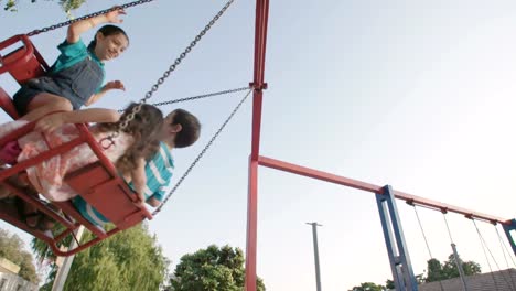 Niños-que-hace-pivotar-juntos-en-un-parque-infantil-público