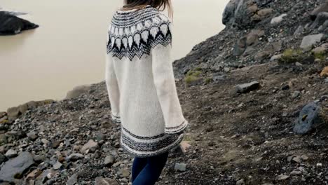 Young-traveling-woman-hiking-in-the-Vatnajokull-glaciers-ice-lagoon,-walking-through-the-rocks-in-the-mountains