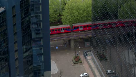 Tranvía-entre-edificios,-trenes-Dlr,-Ticker-financiero,-Canary-Wharf,-Londres