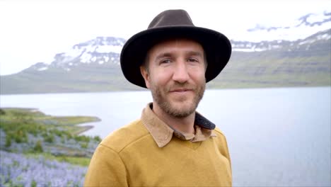 Slow-motion-video-retrato-de-hombre-joven-en-Islandia-cerca-de-lago-y-montañas