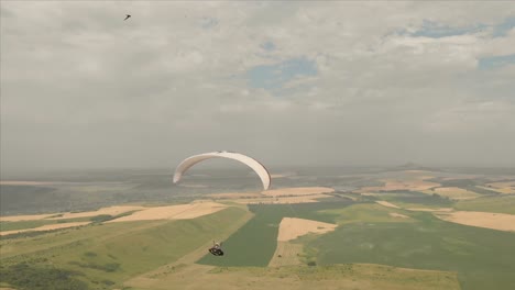 Atleta-paraglider-vuela-en-su-parapente-junto-a-las-golondrinas.-Seguimiento-desde-los-aviones-no-tripulados