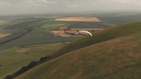 Athlet-Gleitschirm-fliegt-auf-seinem-Gleitschirm-neben-die-Schwalben.-Follow-up-Aufnahmen-aus-der-Drohne