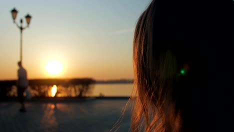 mujer-está-bebiendo-café-en-un-muelle-en-la-hora-del-atardecer,-primer-plano-de-la-cara