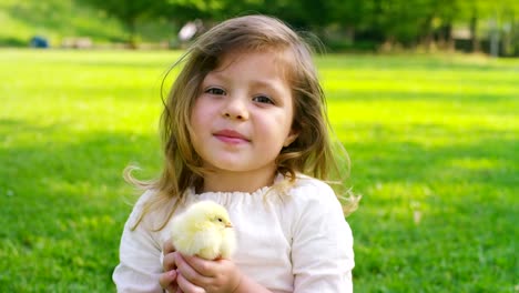 Kleine-Mädchen-spielen-mit-Küken