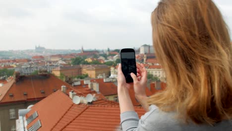 panoramic-view-on-old-buildings-in-Prague-from-top-and-girl-is-taking-pictures-by-smartphone