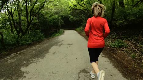 Niña-corriendo.-Chica-rubia-haciendo-deportes-al-aire-libre-en-el-bosque-de-verano.-Parte-trasera-vista-cámara-lenta-gran-angular.-La-niña-corre-en-el-marco-de