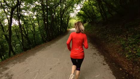 Niña-corriendo.-Chica-rubia-haciendo-deportes-al-aire-libre-en-el-bosque-de-verano.-Gran-angular-de-parte-trasera-vista-cámara-lenta