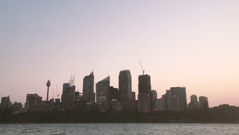 Establishing-shot-of-Sydney-city-skyline-at-harbour-during-sunset.