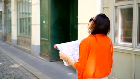 Young-woman-with-a-city-map-in-city.-Travel-tourist-girl-with-map-in-Vienna-outdoors-during-holidays-in-Europe.