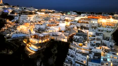 Hyper-Zeitraffer-Flug-über-der-Stadt-Fira-(Thira)-bei-Sonnenuntergang,-Santorin,-Griechenland