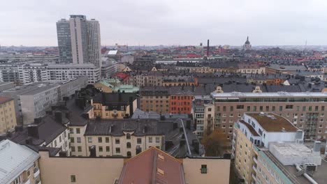 Vista-aérea-de-edificios-de-la-ciudad-de-Stockholm-en-barrio-de-Södermalm.-Tiro-de-Drone-volando-sobre-los-tejados,-rascacielos-en-el-fondo.-Horizonte-de-paisaje-urbano,-Capital-de-Suecia