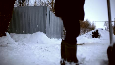 Work-after-snowy-night.-Man-with-a-shovel-removing-the-snow-from-his-yard-on-a-cold-snowy-morning.