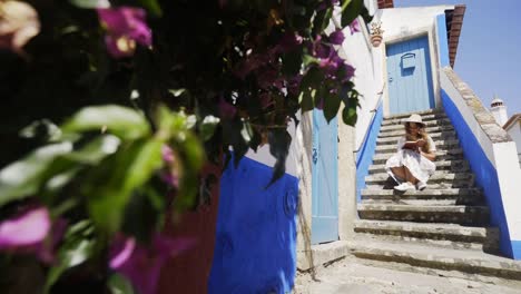 Young-woman-writing-in-notebook-on-steps