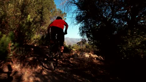 Mountain-biker-Reiten-auf-eine-cross-country-Schotterstrecke