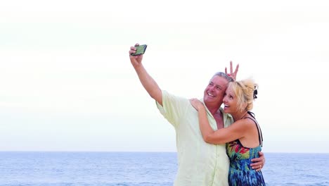 Eine-ältere-paar-Spaß-haben-und-nimmt-selfies-am-Strand